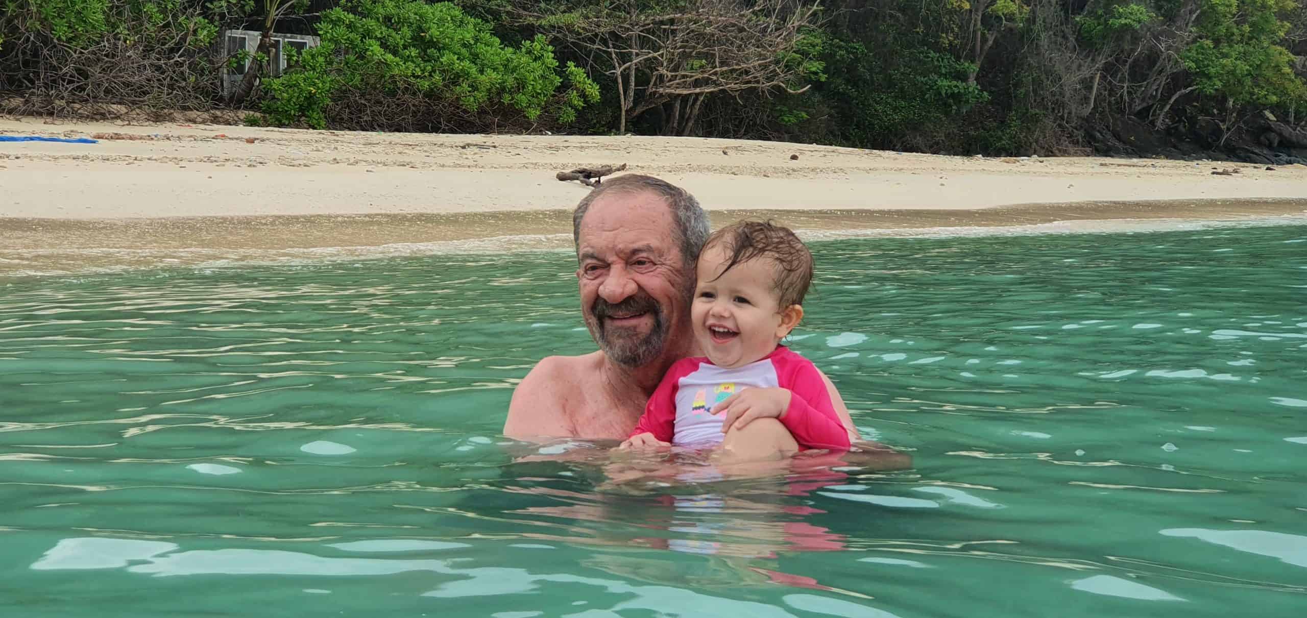 Grandpa swimming with his granddaughter at lon island.